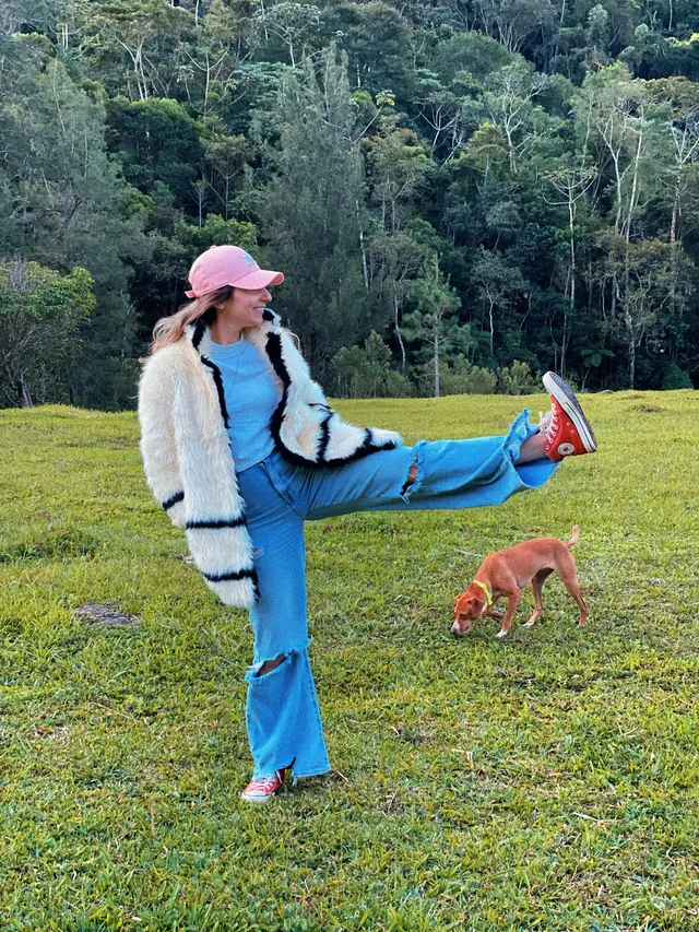 Isabela brincando ao ar livre com um cachorro