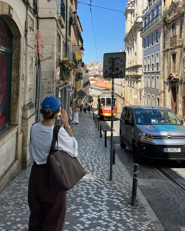 Isabela caminhando por uma rua de Lisboa
